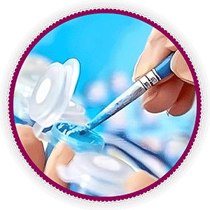 A painting by numbers brush being dipped into blue paint