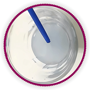 A paint by numbers brush being rinsed in a cup of water